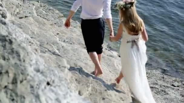 Gli sposi si siedono vicino al fiume il giorno del loro matrimonio. Sfocatura — Video Stock