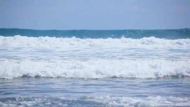Красиві блакитні хвилі з білою піною на березі океану . — стокове відео