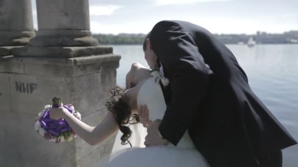 Newlyweds kiss on lake background — Stock Video