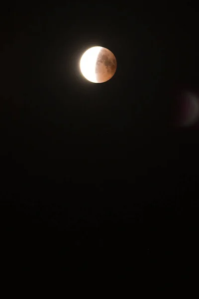 Eclipse lunar. El disco de la luna sobre un fondo negro del cielo nocturno. — Foto de Stock