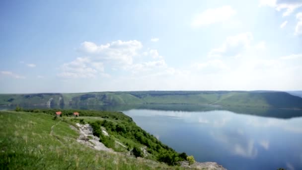 Vue panoramique sur le large fleuve aux berges escarpées, forêt, ciel bleu aux nuages blancs reflétés dans l'eau. Vue aérienne — Video