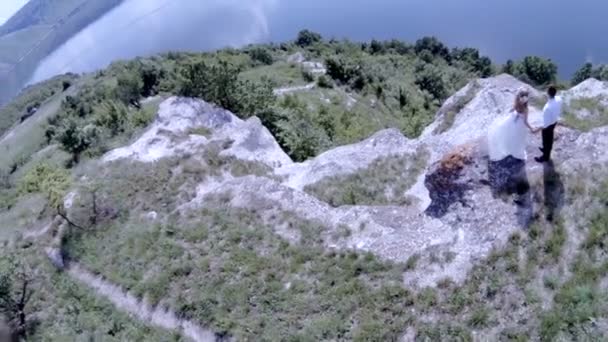 Les mariés se tiennent sur la rive escarpée d'une rivière . — Video