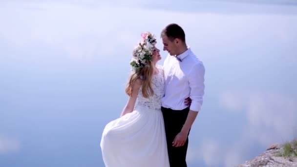 Жених и невеста стоят на крутом берегу реки . — стоковое видео