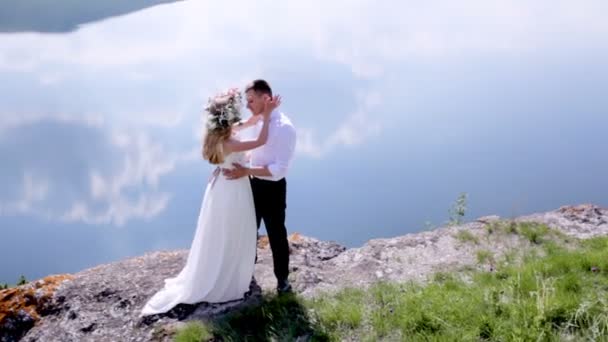 Жених и невеста идут вдоль реки в день свадьбы. — стоковое видео