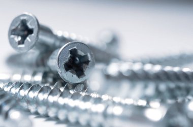 Beyaz arka plandaki mobilyaların vidaları, izole edilmiş. Mobilya montajı kavramı.