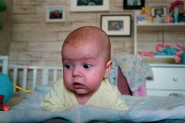 Çekici, gülümseyen yeni doğmuş bir bebeğin portresi. Yeni doğmuş bebek midesinde dinleniyor.