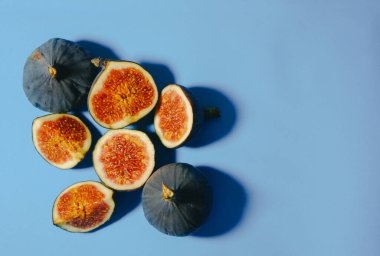 Sarı arka planda taze incir. Masada dilimlenmiş incirler var. Yukarıdan bak. Boşluğu kopyala.