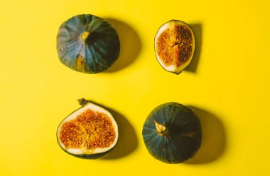 Sarı arka planda taze incir. Masada dilimlenmiş incir.