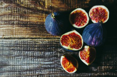 Birkaç incir bütün ve eski bir ahşap masa üzerinde doğranmış, kopyalama alanı