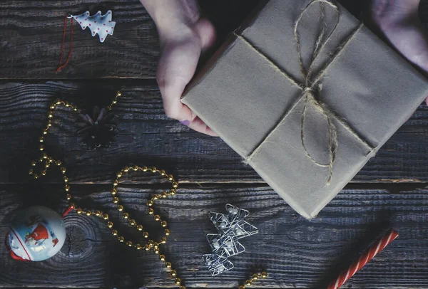 Mãos Uma Menina Segurando Presente Natal Envolto Papel Artesanal Natal — Fotografia de Stock