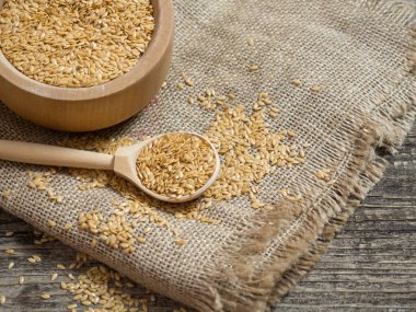 Altın keten tohumu, ahşap kaşıkta keten tohumu yakın plan, beyaz keten tohumu