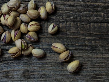Eski ahşap bir masada, fotokopi alanı olan fıstıkların yakın çekimi..