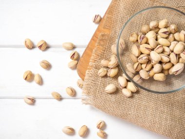 Eski ahşap bir masanın üzerinde temiz cam bir kasede fıstıklar atmosferik bir kırsal kompozisyon, bir kopya alanı.