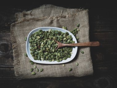 Tahta bir masadaki tahta kaşıkta balkabağı tohumları. metin alanı kopyalanıyor