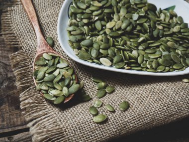 Tahta bir masadaki tahta kaşıkta balkabağı tohumları. metin alanı kopyalanıyor