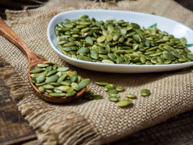 Tahta bir masadaki tahta kaşıkta balkabağı tohumları. metin alanı kopyalanıyor