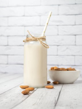 beyaz ahşap bir masada badem ve badem sütü