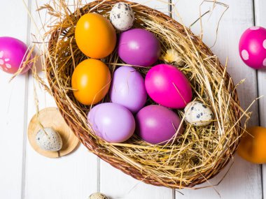 Paskalya yumurtaları, beyaz ahşap arka planda bir yuvada. Paskalya 'nın asgari konsepti. Üst Manzara. Metin için bir paskalya kartı ve yerin bir kopyası..