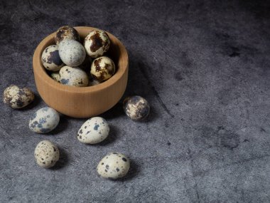 Tahta bir kasede bıldırcın yumurtası. Koyu beton bir arka planda. Üst Manzara. Kopyalamak için boş alan.