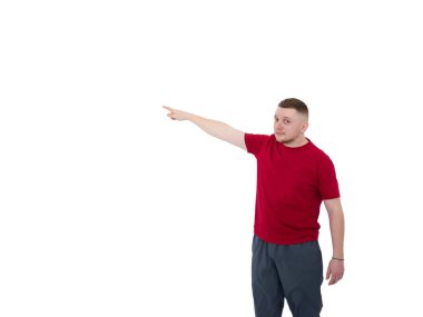 Spor giysili yakışıklı bir gencin portresi beyaz arka planda izole edilmiş bir mesaj için parmağını işaret ediyor.