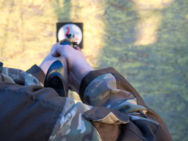 a man aims an air rifle at a target for shooting.