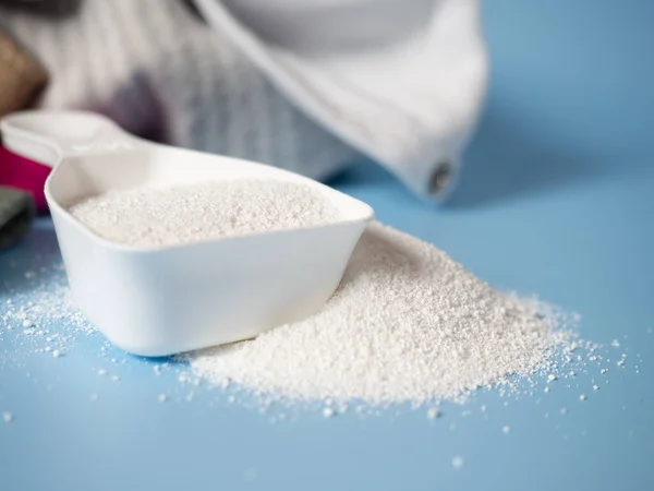 Beyaz faraş ve arka planda bebek yıkama tozu. Çocuk kıyafetlerini yıkamak için deterjan. Kuru temizleme. Düzenli yıkama. - Evet. Pastel mavi arkaplan üzerindeki metin için boş boşluk.