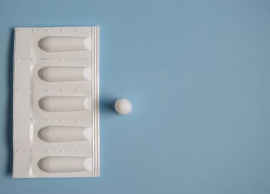 Mavi arka planda anal ya da vajinal kullanım için fitil. Hemoroit, ateş, ardıç, iltihap tedavisi için mumlar.