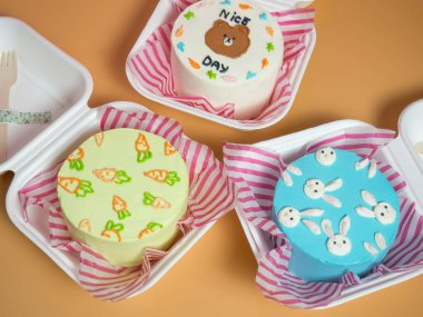 Tahta çatallar ve mumlarla dolu bir karton kutuda renkli güzel pastalar. Tatil fikri, uzay konsepti kopyası.