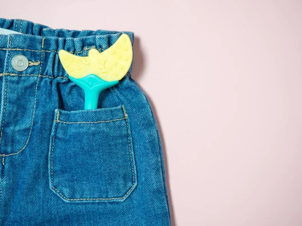 Kinderjeans Mit Einem Spielzeug Der Tasche Großaufnahme Auf Rosa Hintergrund — Stockfoto