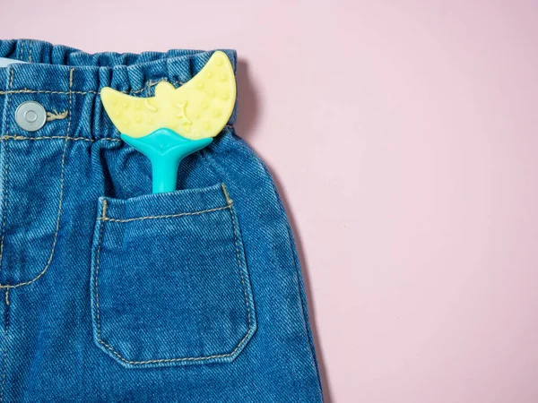 Kinderjeans Mit Einem Spielzeug Der Tasche Großaufnahme Auf Rosa Hintergrund — Stockfoto