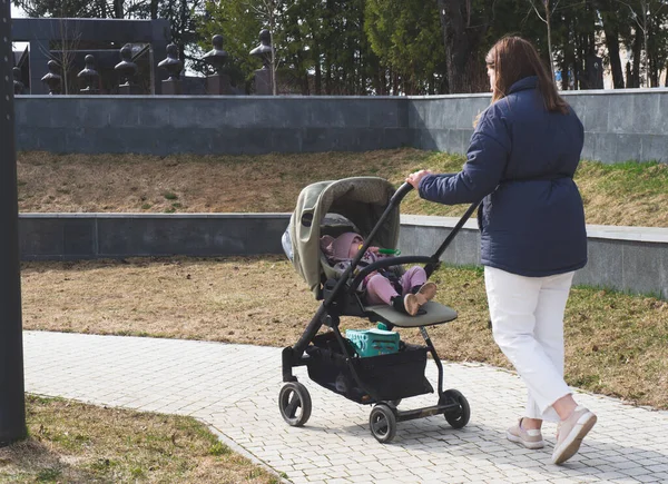 Annem bir bebekle parkta yürüyor.