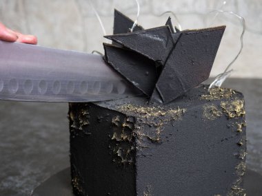 modern siyah kare çikolatalı pasta kadife kaplı ve izomalt ve çikolatayla süslenmiş.