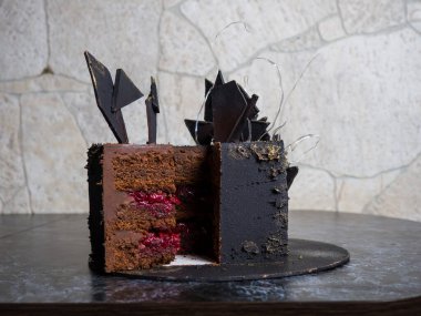 modern siyah kare çikolatalı pasta kadife kaplı ve izomalt ve çikolatayla süslenmiş.
