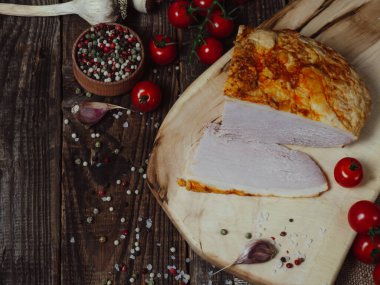 Kesme tahtasının üzerinde tütsülenmiş fileto. Baharatlı füme domuz eti. Ahşap arka planda yakın plan.