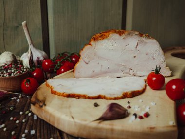 Ahşap bir tahtada kesilmiş domuz eti. Baharatlar, domatesler, kırsal arka plan, yiyecek ve bakkaliye..