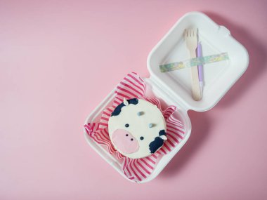 Kore sefertası pastası, pembe arka planda inek suratlı bir pasta. Metnin için yer