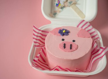 Pembe tonları olan domuz suratlı bir pasta kutusu. Metnin için yer