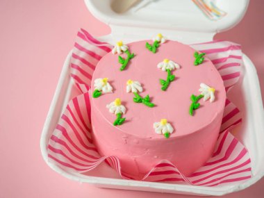 Pembe tonda krema çiçekli Kore yemek kutusu pastası. Metnin için yer