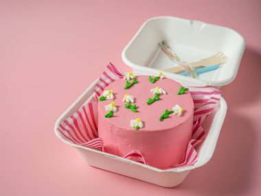 Pembe tonda krema çiçekli Kore yemek kutusu pastası. Metnin için yer