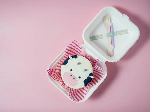 Korean lunch box cake, a cake with a cow's face on a pink background. place for your text