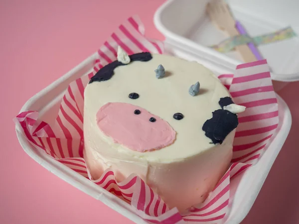 Korean lunch box cake, a cake with a cow\'s face on a pink background. place for your text