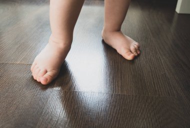 Çocukların ayakları ilk adımlarını atar. Bir çocuğun ilk adımları.
