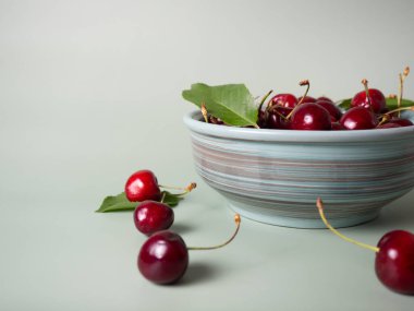 ripe cherries in a bowl on a menthol background with place for your text