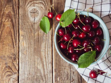 ripe cherries on an old wooden rustic table with place for text