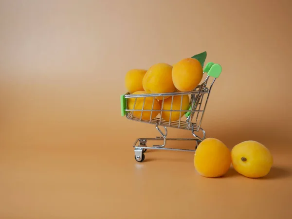 Supermarket Cart Filled Ripe Apricots Beige Background Close — Fotografia de Stock