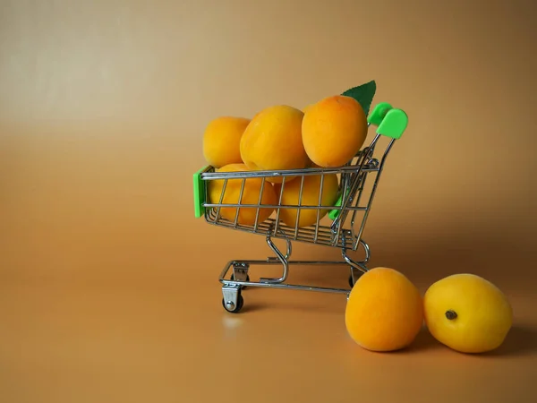 Supermarket Cart Filled Ripe Apricots Beige Background Close — Stockfoto