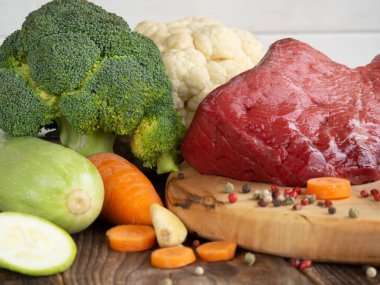 beef tenderloin and vegetables on rustic wooden background