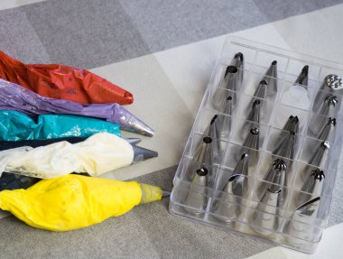 pastry bags with multi-colored cream and nozzles lie on the table