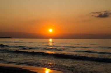 Denizde güzel bir gün batımı. Gün batımında plaj ve sörf.