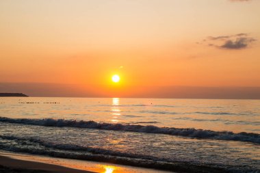 Denizde güzel bir gün batımı. Gün batımında plaj ve sörf.